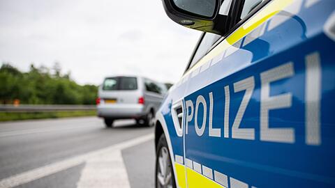 Ein Streifenwagen der Polizei steht auf einer Straße.