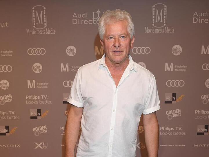 Der Schauspieler Miroslav Nemec steht mit Badeschlappen auf dem Roten Teppich. Foto: Felix Hörhager