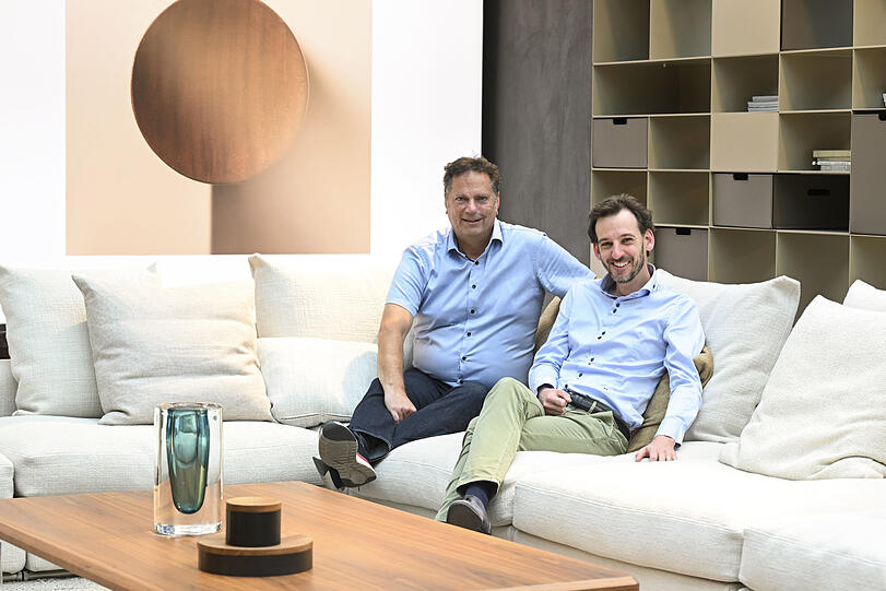 Thomas Böhmler (60) und sein Neffe Matthias Böhmler (39) führen das Einrichtungshaus im Tal in der vierten und fünften Generation. Das riesige Sofa, auf dem die beiden sitzen  – und von dem auf dem Bild nur etwa ein Fünftel zu sehen ist – kostet über 30.000 Euro.