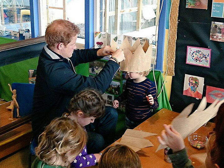 Prinz Harry platziert liebevoll eine Papierkrone auf dem Kopf des Jungen