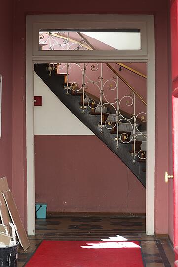 Blick in einen alten Flur und das schmucke Treppenhaus.