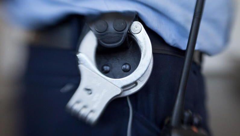 Handschellen hängen am Gürtel eines Justizbeamten. Foto: Friso Gentsch/dpa/Symbolbild Handschellen hängen am Gürtel eines Justizbeamten. Foto: Friso Gentsch/dpa/Symbolbild