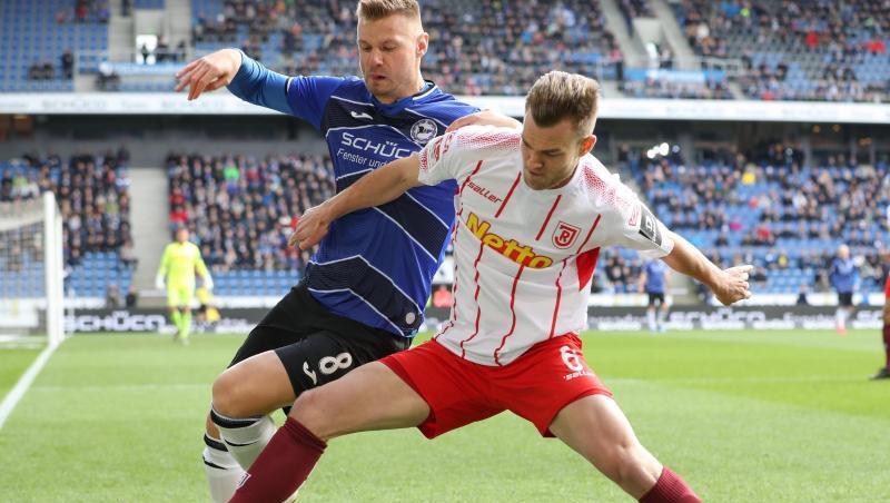 Bielefelds Florian Hartherz (l.) im Kampf um den Ball mit Benedikt Saller (r.) aus Regensburg. Foto: Friso Gentsch/dpa Bielefelds Florian Hartherz (l.) im Kampf um den Ball mit Benedikt Saller (r.) aus Regensburg. Foto: Friso Gentsch/dpa