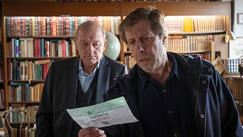 "Wilsberg: Todsicherer Tipp": Privatdetektiv Georg Wilsberg (Leonard Lansink, l.) und Ekki Talk&ouml;tter (Oliver Korittke) entdecken zwischen den Seiten eines alten Buches etwas Unerwartetes.
