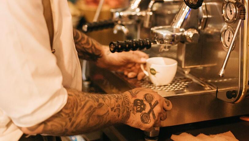 "Florian Nagel führt ein außergewöhnliches Retro-Café im oberbayerischen Skiort. Dort trifft man den ambitionierten Cafébetreiber persönlich an, in einem denkmalgeschützten Garmischer Haus mit prachtvoller Fassade. Seine Begeisterung für Kaffee trägt er sichtbar auf seinen Handrücken spazieren &ndash; als Tattoos in Form von Siebträgern."