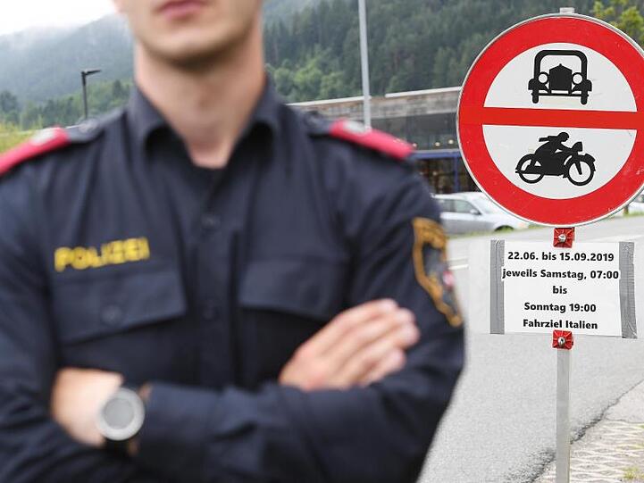 Ein Polizist steht vor einem Schild, das auf die Sperrung für den Verkehr hinweist. Foto: Angelika Warmuth/Archivbild