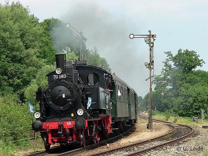 Die Dampflokomotive 70 083 mit grünen Plattformwagen.