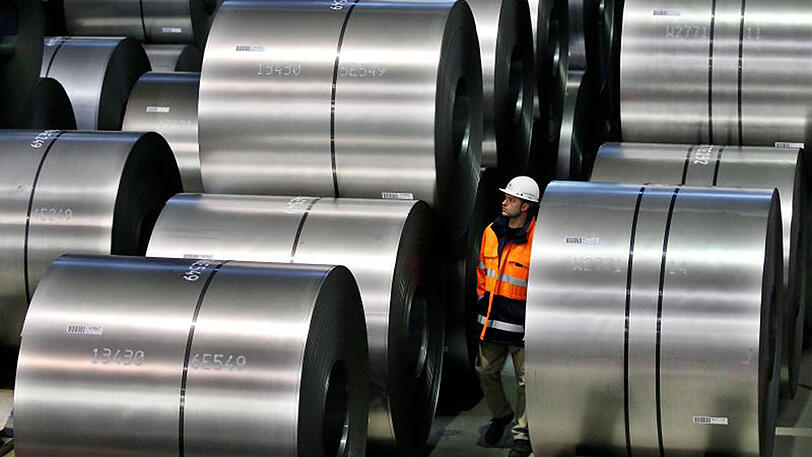 Ein Mitarbeiter von Thyssenkrupp schaut sich im Duisburger Stahlwerk Rohstahlrollen an.