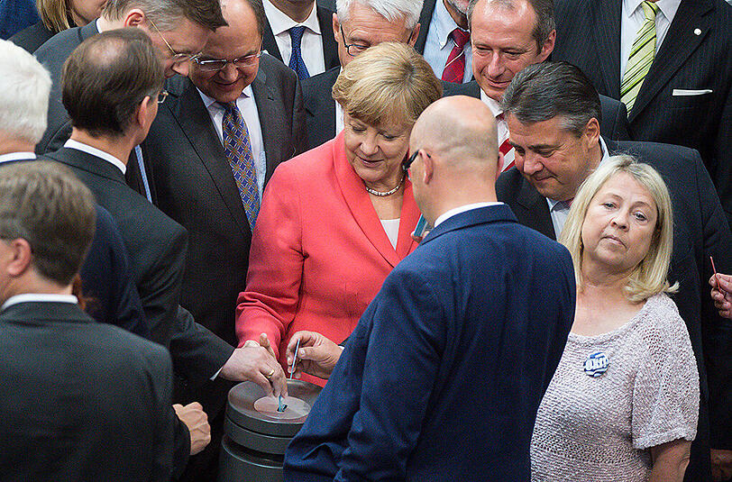 Bundeskanzlerin Angela Merkel (M, CDU) und Bundeswirtschaftsminister Sigmar Gabriel (r, SPD) werfen am 17.07.2015 während der Sondersitzung des Deutschen Bundestags zu Griechenland-Hilfspaketen in Berlin ihre Stimmkarten in die Urne.