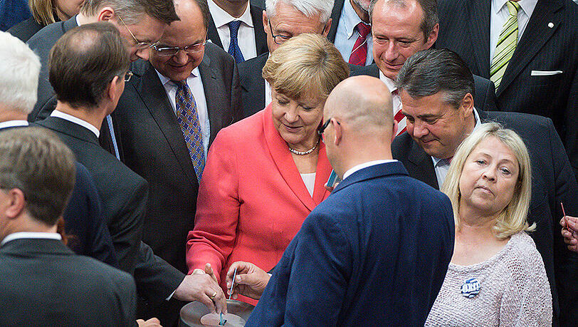 Bundeskanzlerin Angela Merkel (M, CDU) und Bundeswirtschaftsminister Sigmar Gabriel (r, SPD) werfen am 17.07.2015 während der Sondersitzung des Deutschen Bundestags zu Griechenland-Hilfspaketen in Berlin ihre Stimmkarten in die Urne. Bundeskanzlerin Angela Merkel (M, CDU) und Bundeswirtschaftsminister Sigmar Gabriel (r, SPD) werfen am 17.07.2015 während der Sondersitzung des Deutschen Bundestags zu Griechenland-Hilfspaketen in Berlin ihre Stimmkarten in die Urne.