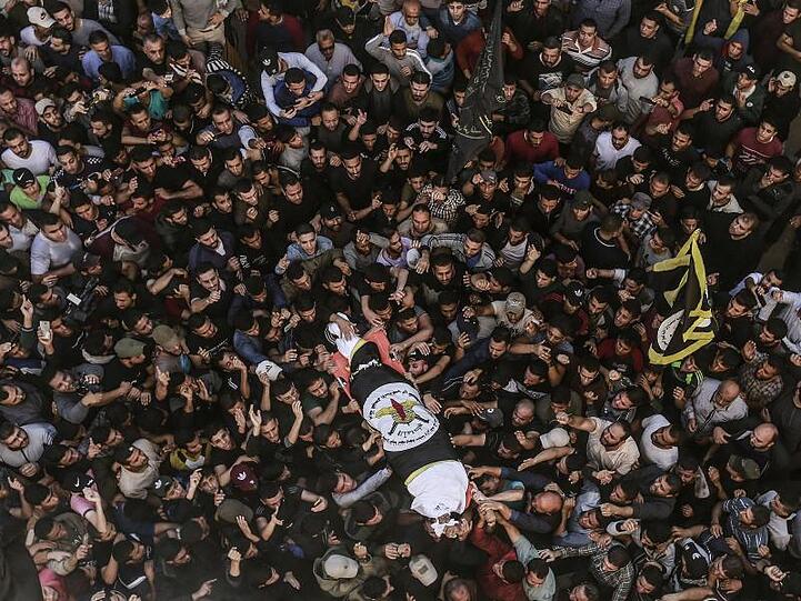 Eine Menschenmenge trägt den eingewickelten Körper von Dschihad-Militärchef Baha Abu Al Ata in Gaza-Stadt zu Grabe.