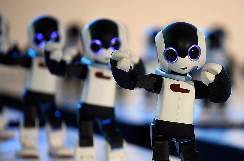 Einhundert humanoide Roboter namens "Robi" tanzen auf einem Event.