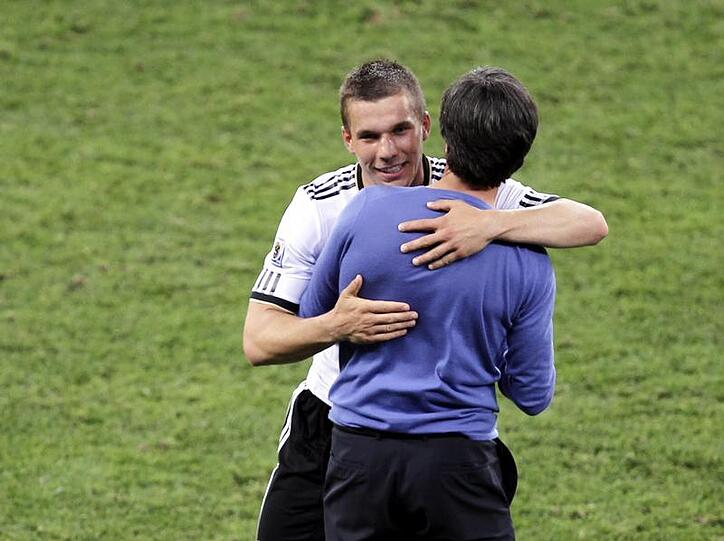 Joachim Löw umarmt den Torschützen zum 1:0 Lukas Podolski (l.) nach dem Spiel.
