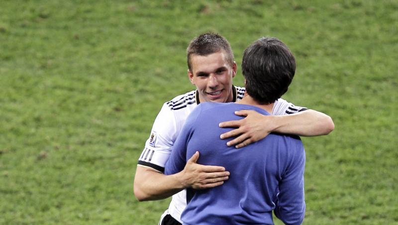 Joachim Löw umarmt den Torschützen zum 1:0 Lukas Podolski (l.) nach dem Spiel.