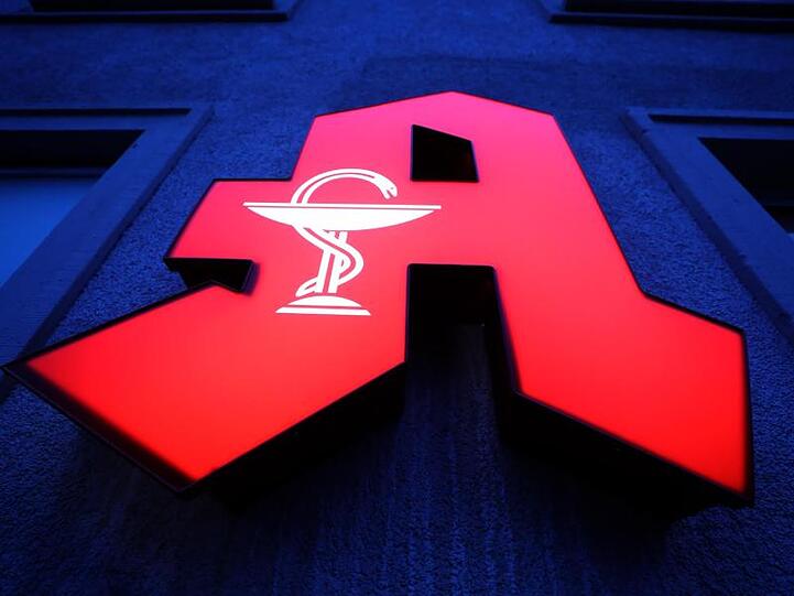 Ein großes rotes "A" leuchtet vor einer Apotheke.