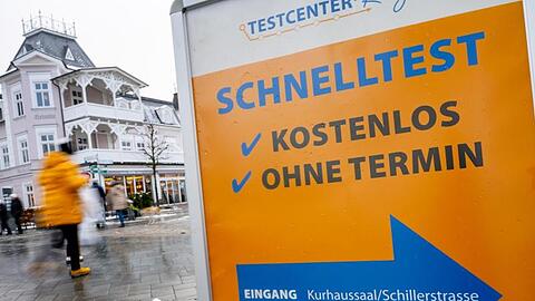 Ein Schild verweist auf ein Corona-Testzentrum im Ostseebad auf Rügen.