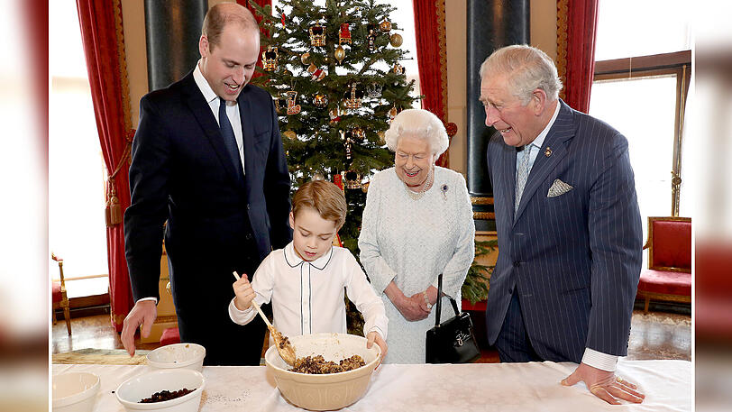 Die volle Aufmerksamkeit seines Vaters Prinz William (li.), seiner Urgroßmutter Königin Elizabeth II. und seines Großvaters Prinz Charles (re.) hat der kleine Prinz George bei der Zubereitung des traditionellen Christmas Puddings im Musikzimmer des Buckingham-Palasts.