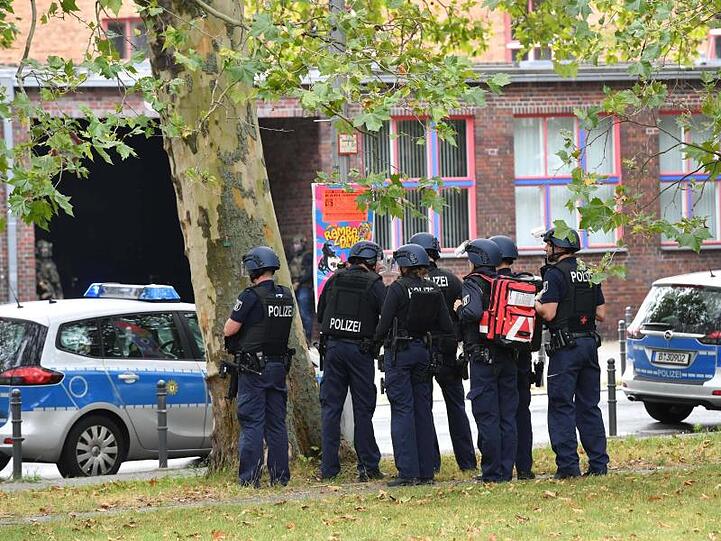 Einsatzkräfte der Polizei stehen an einem Oberstufenzentrum in Rummelsburg.