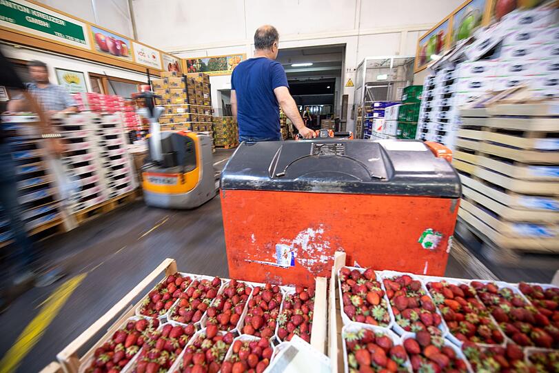Erdbeeren werden in der Halle 1 vom Großmarkt München mit einem Hubwagen an einen Kunden ausgeliefert.