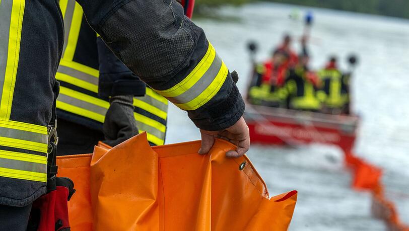Feuerwehrleute errichten auf der Donau eine &Ouml;lsperre. (Symbolbild)