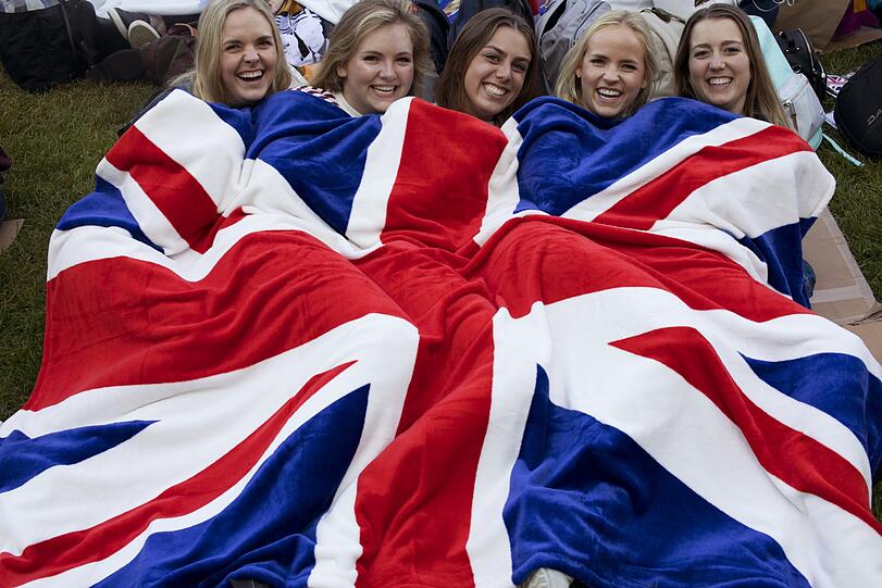 Fans liegen unter einer Decke in den Farben der britischen Fahne vor Beginn der Hochzeitsfeierlichkeiten.
