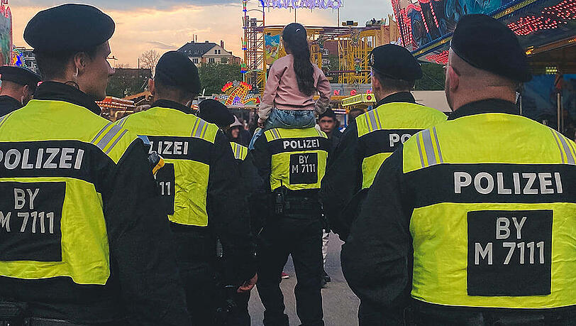 Ein Beamter der Polizei trägt das Mädchen auf den Schultern.
