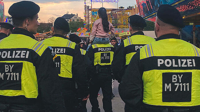 Ein Beamter der Polizei trägt das Mädchen auf den Schultern.