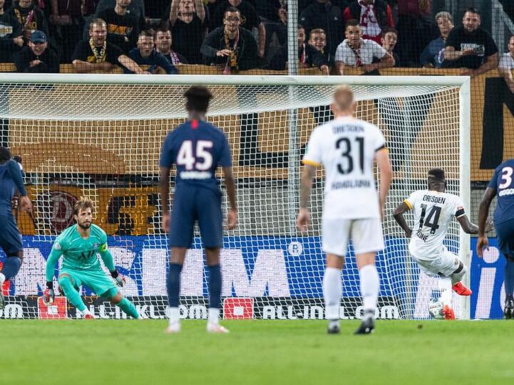 Dynamos Moussa Kone (2.v.r) verlädt PSG-Keeper Kevin Trapp vom Elfmeterpunkt und trifft zum 1:6.