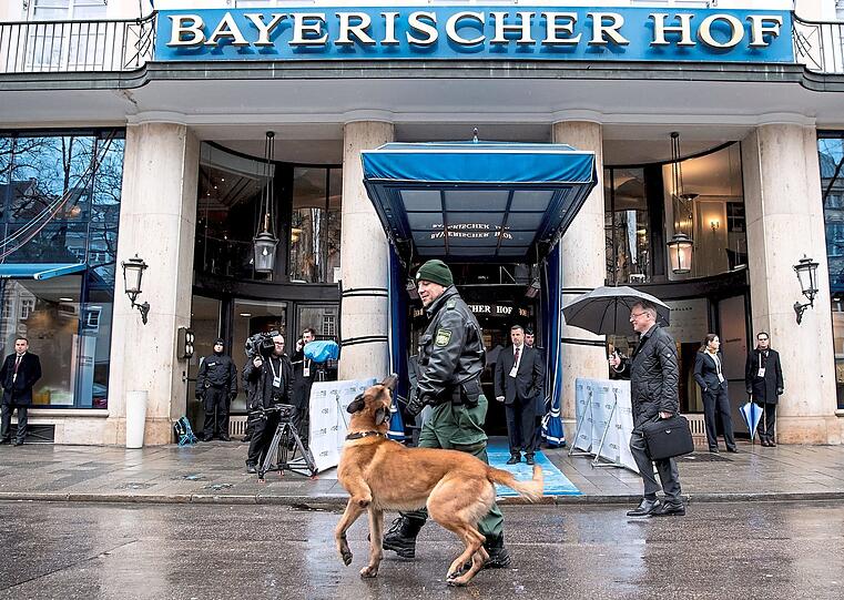 Bildfunk +++ Ein Polizist mit Sprengstoffhund vor dem "Bayerischen Hof". Fotos: dpa