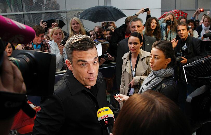 Weltstar im Fan-Gewusel: Robbie Williams verteilte Autogramme vor dem Mathäser-Kino.