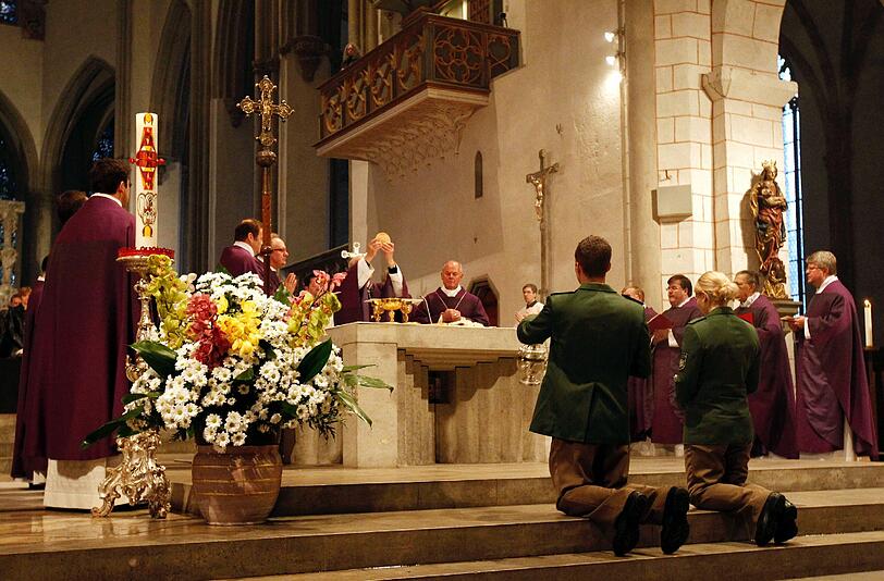 Zwei Polizisten knien vor dem Altar.