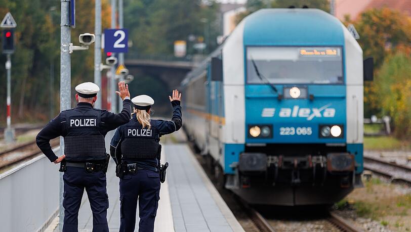 Bundespolizisten weisen per Handzeichen den Lokf&uuml;hrer eines Zuges aus Prag in Richtung M&uuml;nchen darauf hin, dass sie zur Kontrolle des Einreiseverkehrs zusteigen werden. (Archivbild)