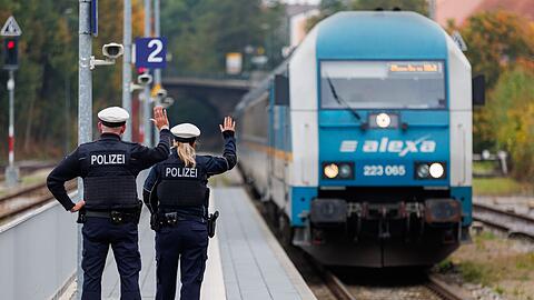 Bundespolizisten weisen per Handzeichen den Lokf&uuml;hrer eines Zuges aus Prag in Richtung M&uuml;nchen darauf hin, dass sie zur Kontrolle des Einreiseverkehrs zusteigen werden. (Archivbild)