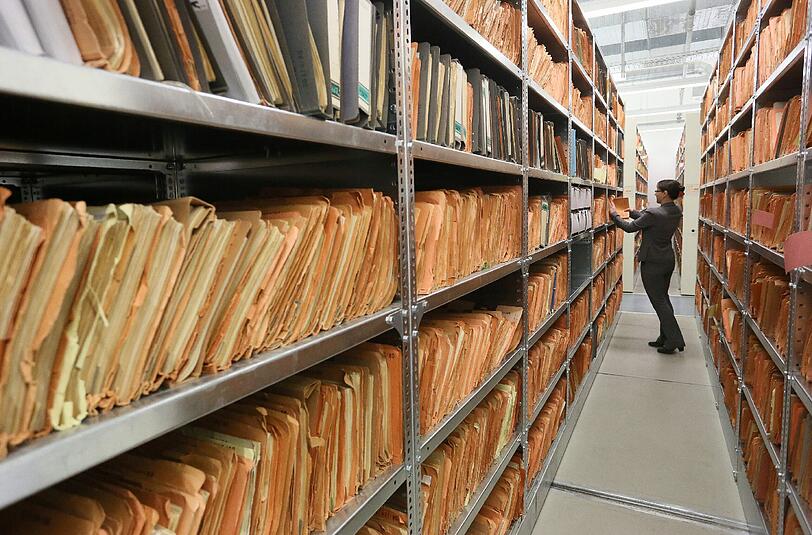 Eine Mitarbeiterin des Stasi-Museums steht im Stasi-Archiv zwischen Regalen mit bisher nicht erfassten Unterlagen (Archivbild). Foto: Stephanie Pilick