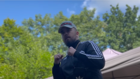 Die klischeehafte Darstellung eines "Talahons" in dem Musikvideo "Verliebt in einen Talahon": ein Mann mit Kappe und Kette, der schattenboxt.