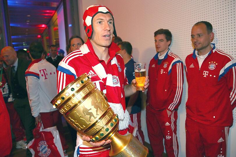 Die Bayern feiern: Nach dem Sieg gegen Borussia Dortmund im DFB-Pokalfinale lässt der FC Bayern in Berlin die Korken knallen. Hier die Feierbilder aus der Telekom-Zentrale.