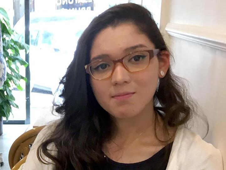 Estefania aus Venezuela sitzt in einer venezuelanischen Bäckerei in Madrid. Die junge Frau ist vor den Zuständen in ihrer Heimat geflohen.