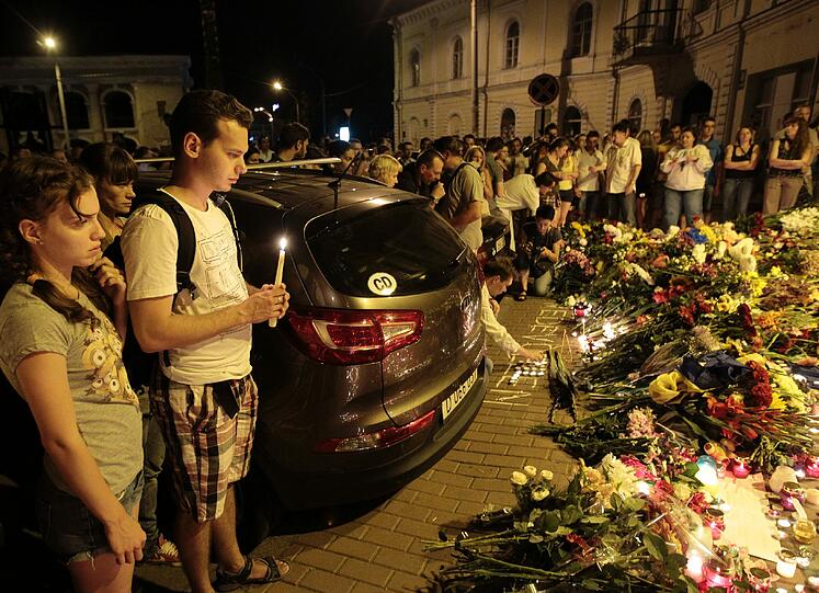 Vor der niederländischen Botschaft in Kiew legen Menschen Blumen nieder und gedenken der Opfer.