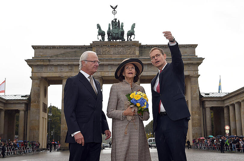 König Carl Gustaf (l) und Königin Silvia stehen mit Berlins Regierendem Bürgermeister Michael Müller (SPD) vor dem Brandenburger Tor.