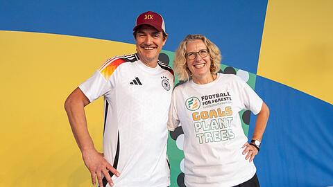 Matze Knop mit Dr. Charlotte Streck, der Gründerin von Football for Forest, auf einer Fan-Veranstaltung im Rahmen der Fußball-EM 2024 in Köln.