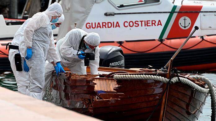 Italienische Forensiker begutachten das beschädigte Holzboot.