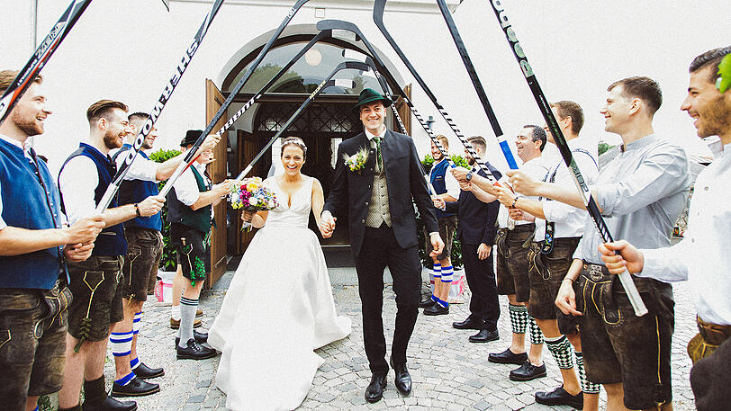Ehrenspalier aus Eishockey-Schlägern: Konrad Abeltshauser mit seiner Ehefrau Erica nach der Trauung.