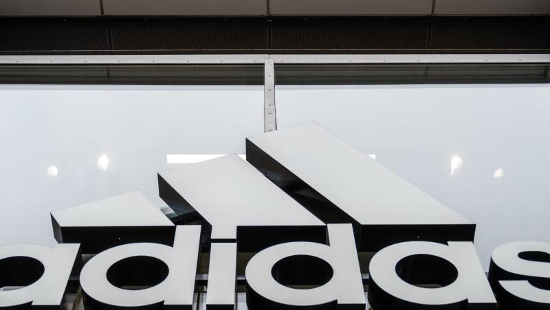 An der Fassade des Adidas Stores hängt das Logo des Unternehmens.