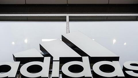 An der Fassade des Adidas Stores hängt das Logo des Unternehmens.