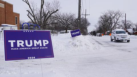 Ein Wahlplakat des ehemaligen US-Präsidenten Trump steht in Des Moines bei eisiger Kälte im Schnee.
