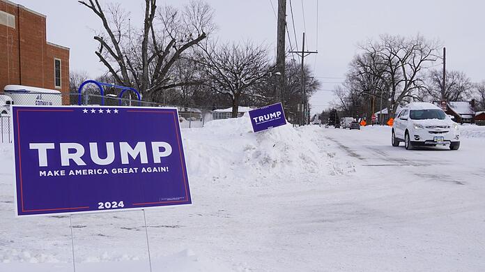 Ein Wahlplakat des ehemaligen US-Präsidenten Trump steht in Des Moines bei eisiger Kälte im Schnee.
