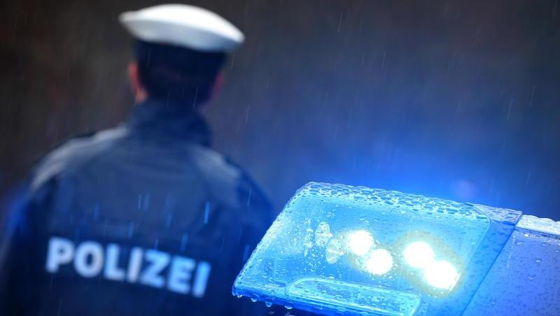 Ein Polizist steht vor einem Streifenwagen. Die drei Erpresser wurden nach der Festnahme ihren Eltern übergeben (Symbolbild).