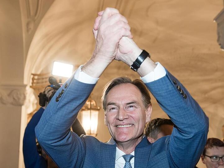Burkhard Jung (SPD), der wiedergewählte Oberbürgermeister von Leipzig, jubelt beim Betreten des Rathauses.