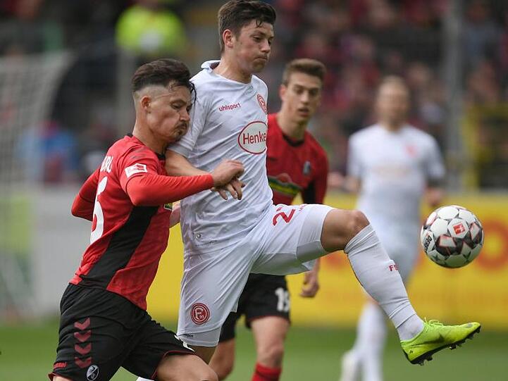 Freiburgs Robin Koch (l) und Düsseldorfs Dawid Kownacki trennen sich unentschieden.