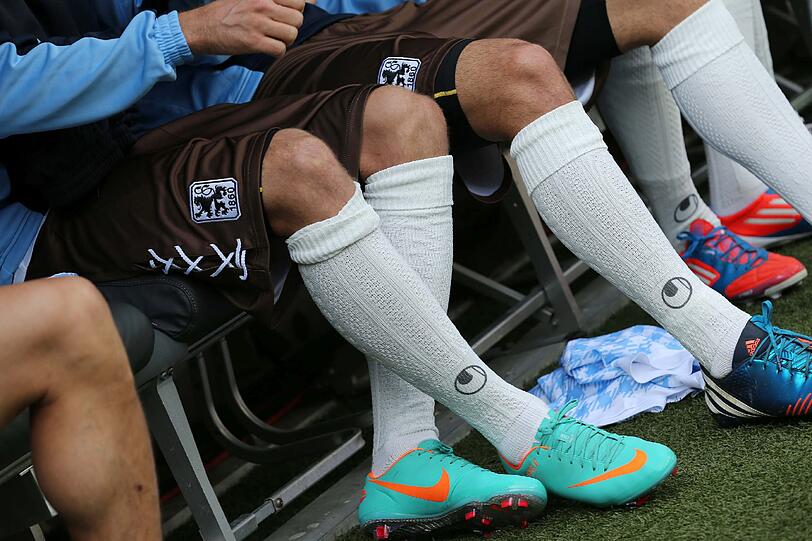 Weiß-blau kariertes Trikot, braune Hosen, weiße Stutzen.